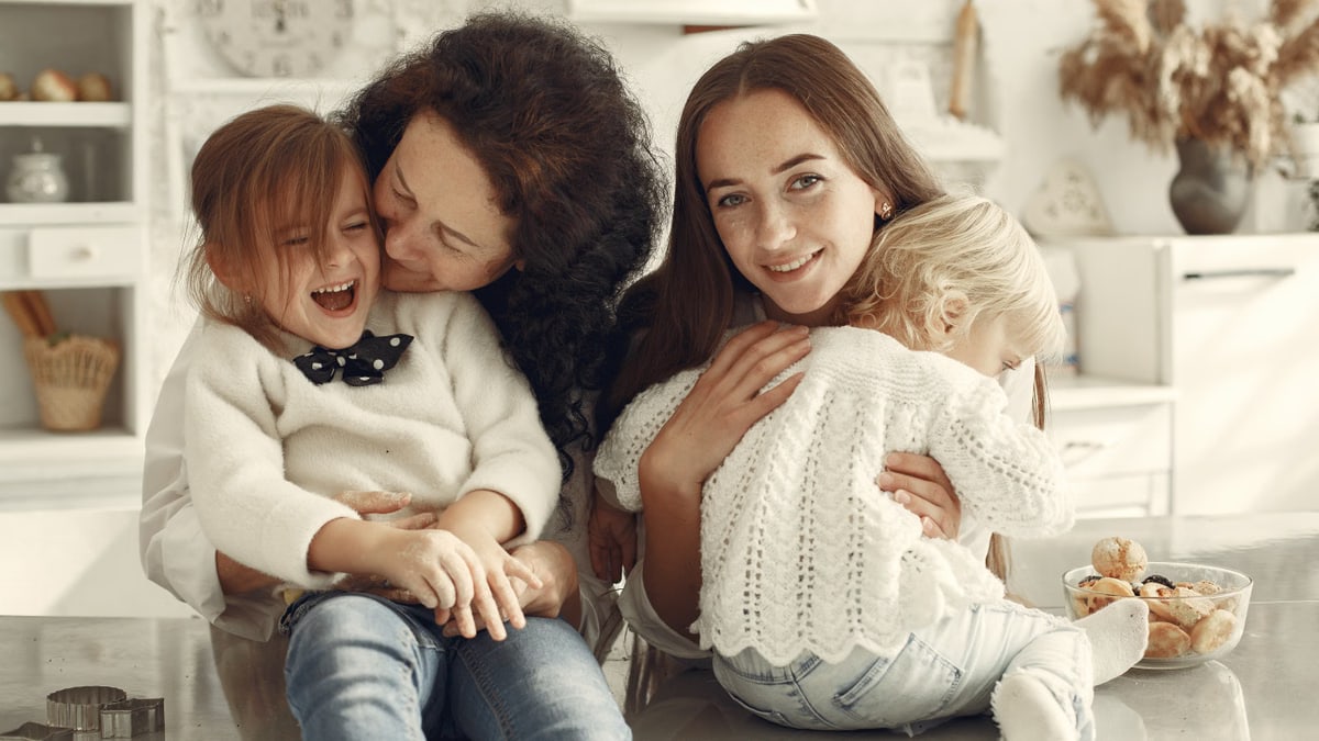A joyful family gathering in a cozy kitchen with three generations bonded in happiness.